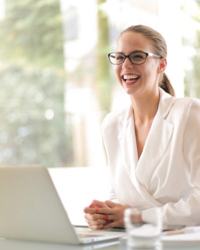 laughing-businesswoman-working-in-office-with-laptop-3756679